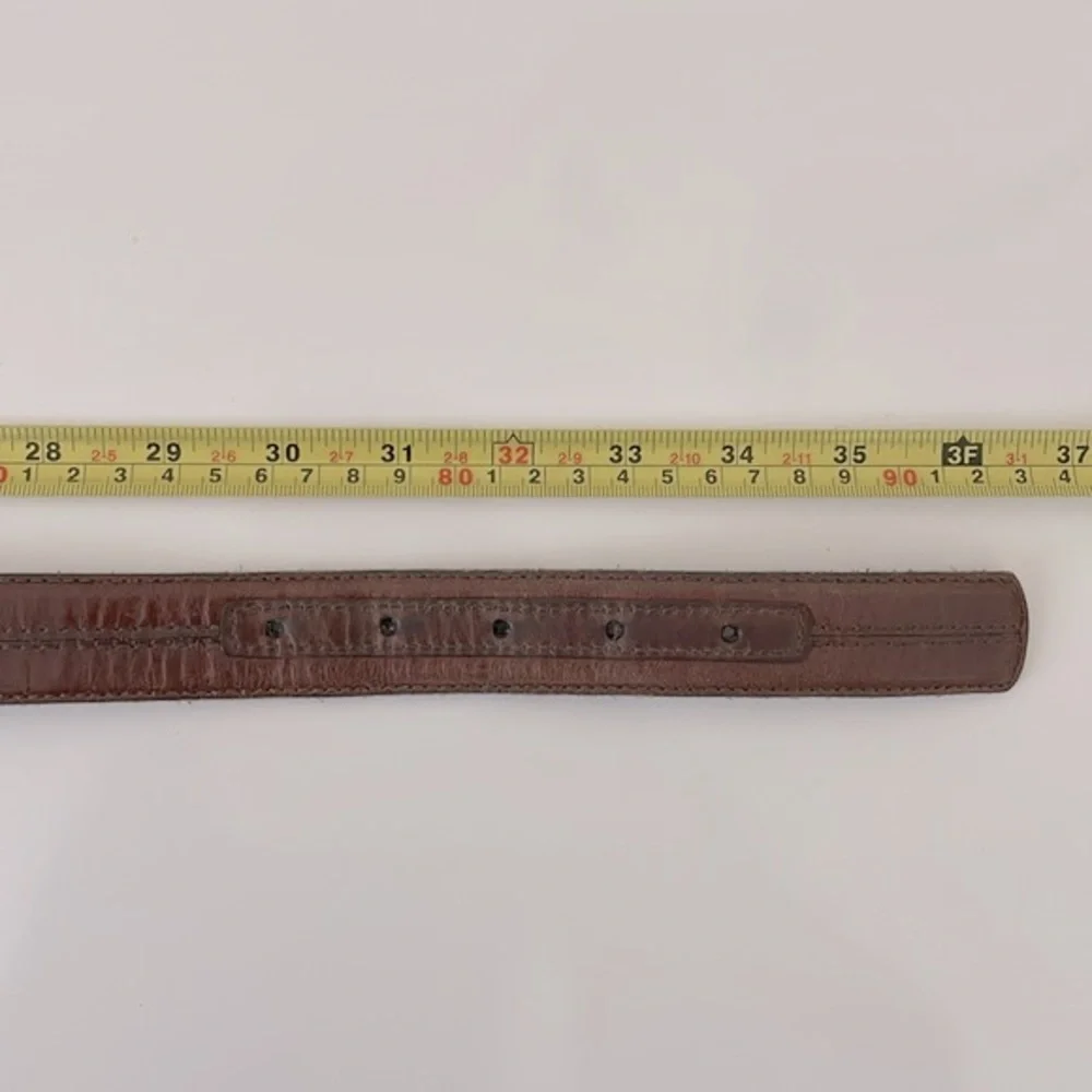 Brown leather belt with center stitch details. Size 32. ‎ Solid brass buckle.